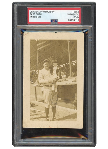 C. 1930S BABE RUTH HOLDS YOUNGSTER BY DUGOUT ORIGINAL PHOTOGRAPH - PSA/DNA TYPE I