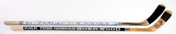 PAIR OF RAYMOND BOURQUE BOSTON BRUINS GAME USED STICKS - SINGLE SIGNED AND TEAM SIGNED