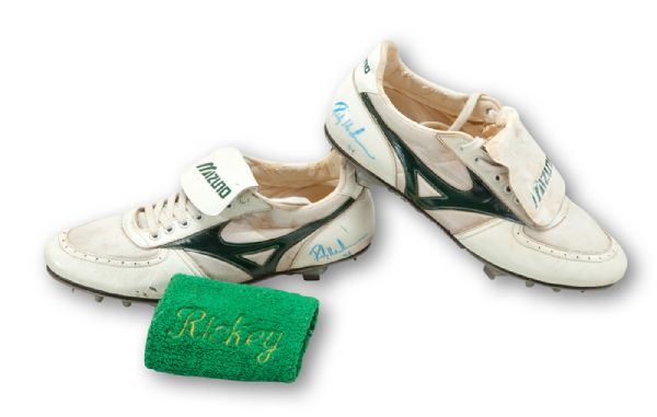 1994 RICKEY HENDERSON OAKLAND AS GAME-WORN MIZUNO SPIKES (BOTH SIGNED) AND GAME-WORN "RICKEY" WRISTBAND