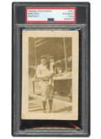 C. 1930S BABE RUTH HOLDS YOUNGSTER BY DUGOUT ORIGINAL PHOTOGRAPH - PSA/DNA TYPE I